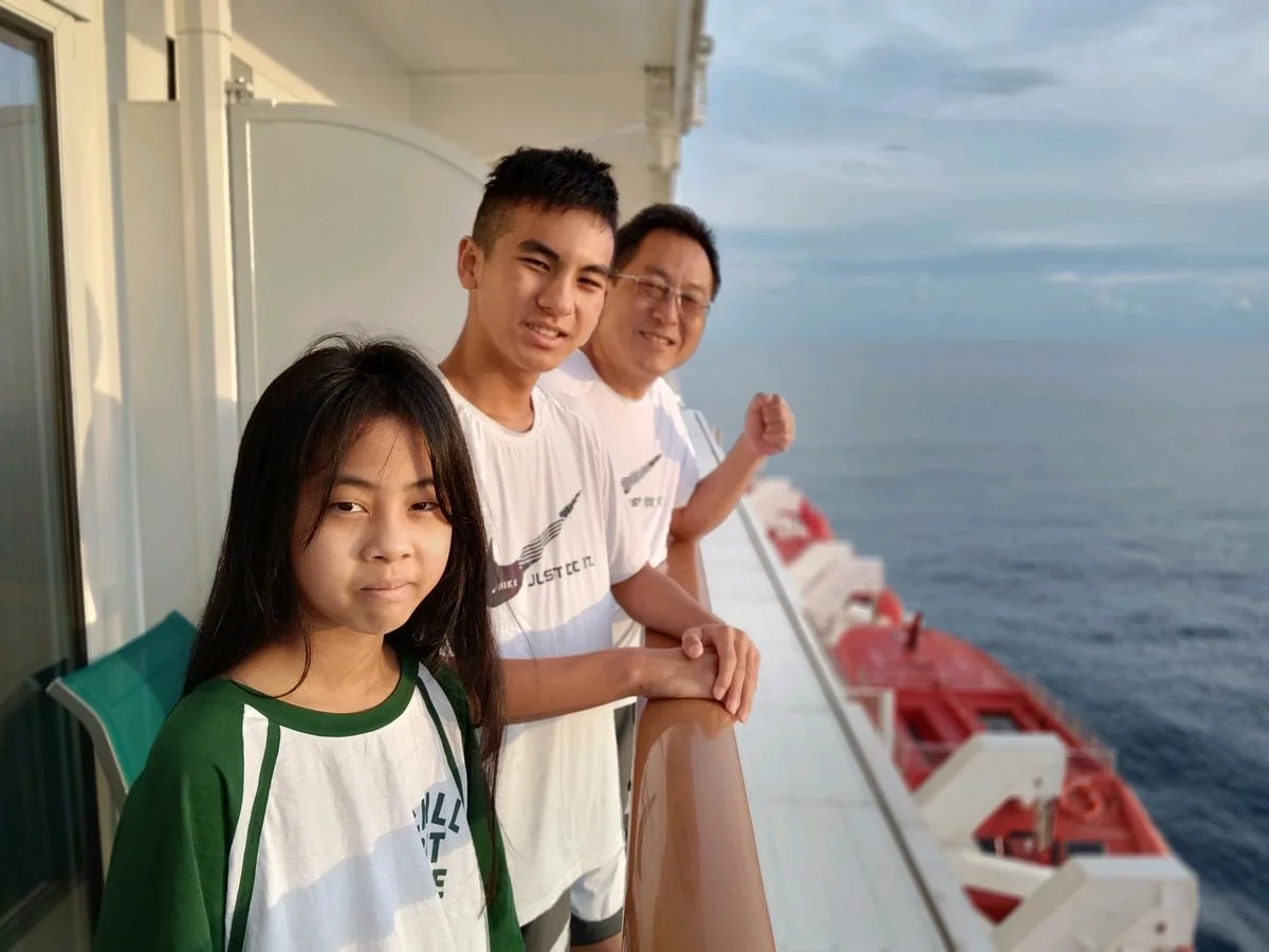 Family taking a selfie on the pool deck of Genting Dream