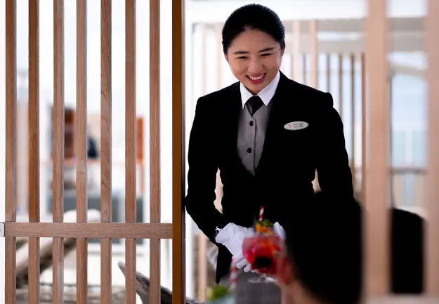 Professional butler offering personalized service at The Palace, Genting Dream Cruise