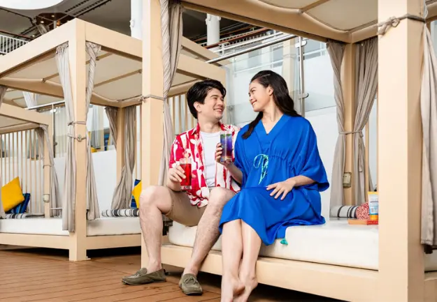 Couple enjoying private cabana experience at The Palace on Genting Dream Cruise