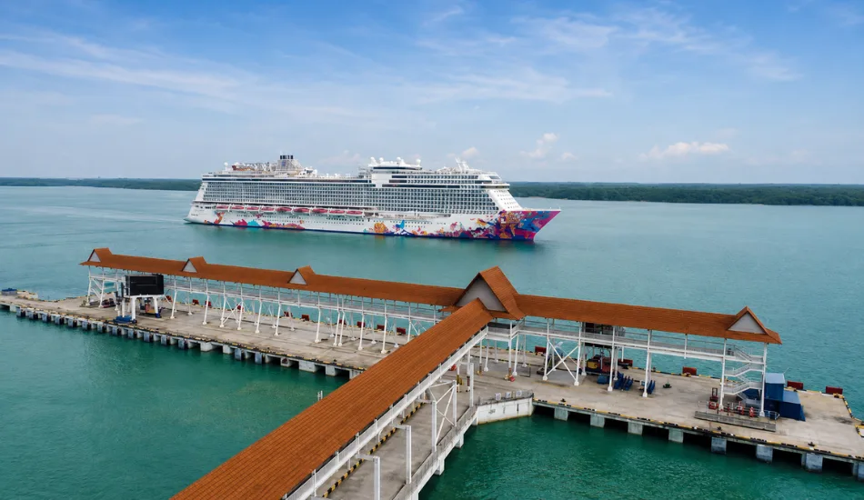 Genting Dream docked at Port Klang Malaysia cruise terminal with tourists disembarking