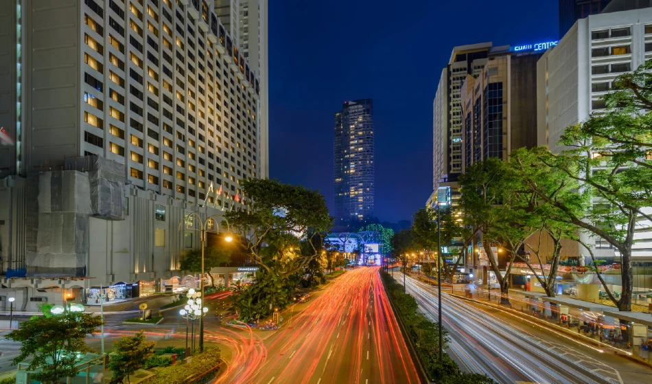 Orchard Road lit up at night with shoppers and malls