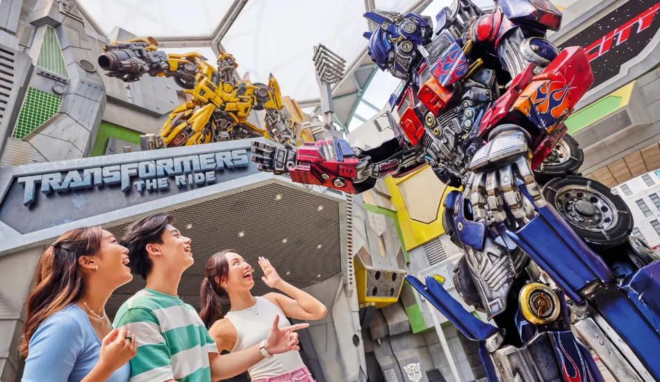 Visitors posing with Optimus Prime at Transformers The Ride in Universal Studios Singapore