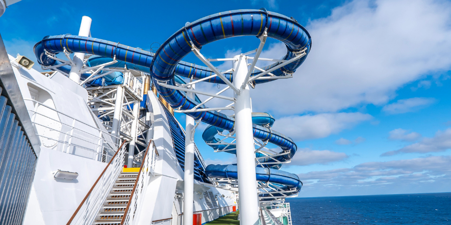Blue spiral water slides on the deck of Star Voyager Cruise with ocean view in the background