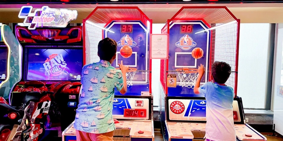 Kids enjoying basketball arcade games onboard Genting Dream