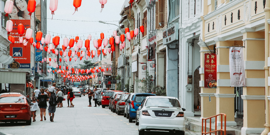 Colorful lanterns hanging over a bustling heritage street in George Town, Penang